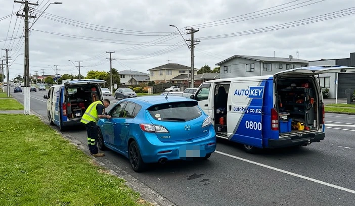 AutoKey mobile van and technician programming a key for a blue 2009 Mazda 3 on the roadside in Manurewa, Auckland